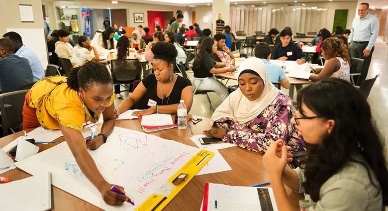 Etta Madete, an architect from Kenya and CEO of affordable housing developer, Zima Homes, works with students in a summer supply chain management program.