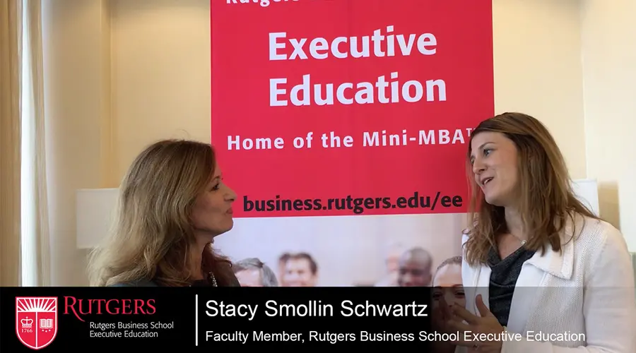 Screenshot of video where Stacy Smollin Schwartz is talking to Jackie Scott in front of an Executive Education banner