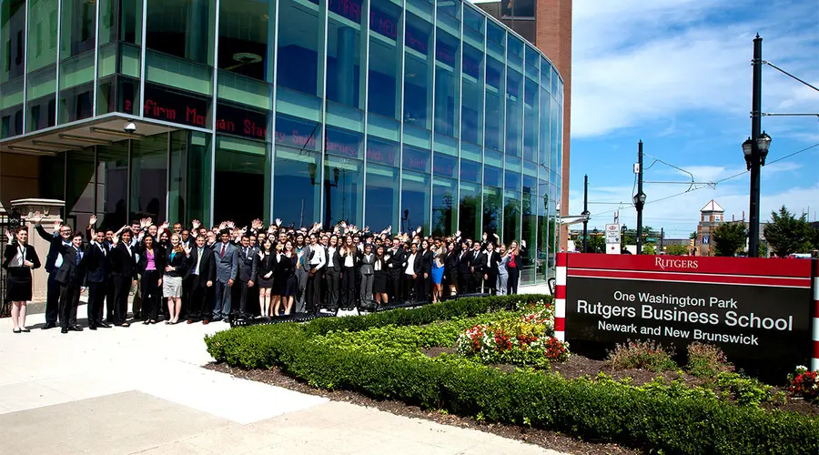 MBA graduating class gathers and waves outside the building at 1 Washington Park