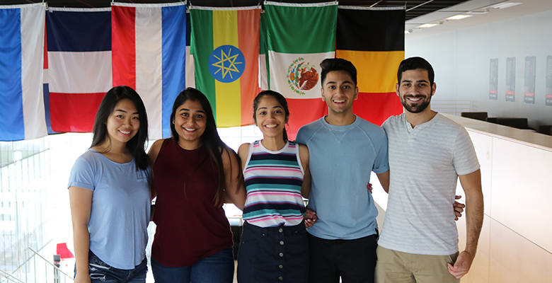 students posing in front of different country's flags