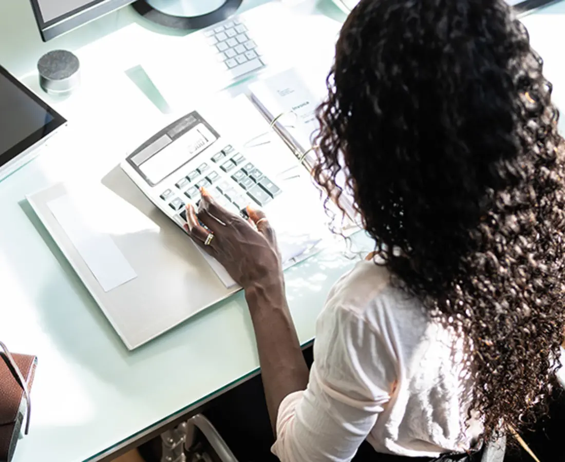 woman in a wheelchair using a calculator