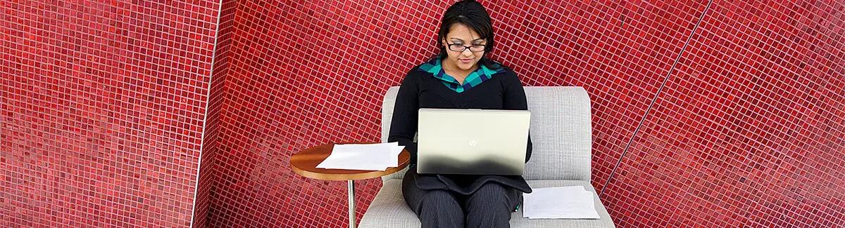 girl sitting on chair using a laptop