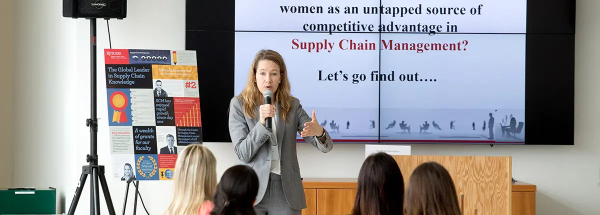 A professor presents a slideshow presentation about supply chain management and how women can be tapped into as a source for competitive advantage.