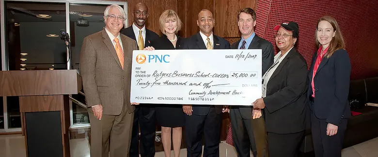 Members of CUEED holding a check from Community Development Banking