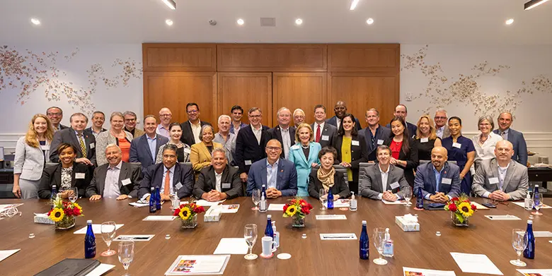 Rutgers Business School Dean Lei Lei and her board of advisors with Rutgers University President Jonathan Holloway.