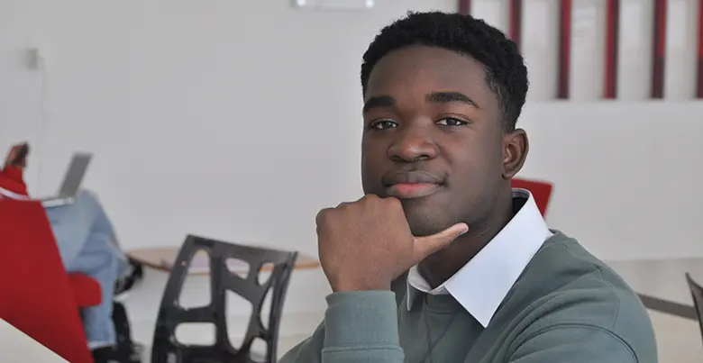 Rutgers Business School sophomore Alex Simeon, a finance major and student entrepreneur, looks into camera.