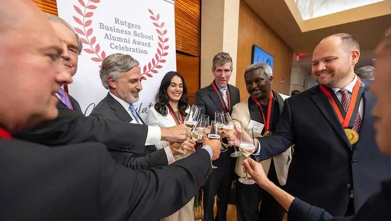 Award recipients raise glasses of champagne in a toast with Rutgers Business School Dean Lei Lei.
