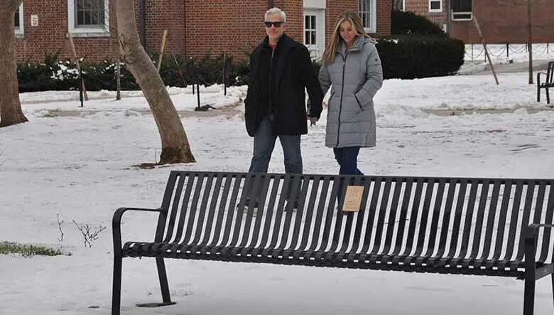 Jim and Maya Colitsas , two Rutgers Business School alumni, stroll near a bench they named at Voorhees Mall on the College Avenue Campus.
