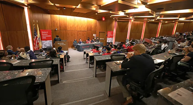 A photo of Bove Auditorium filled with graduating students with speakers seated at the front.