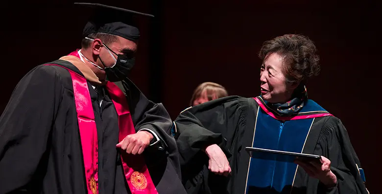Rutgers Business School Dean Lei Lei offered elbow bumps to each of the graduating students.