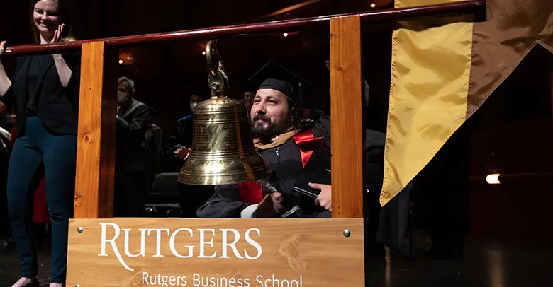 MBA graduate Evan Gerbino ends the graduate program convocation by ringing the school bell.