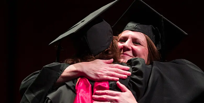Rutgers Business School professor Stacy Schwartz embracing a graduating student from her program during convocation.