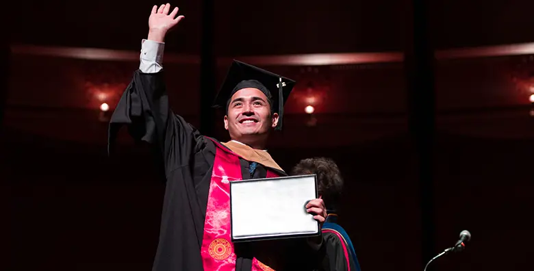 A Rutgers Business School graduate pauses center stage to celebrate his accomplishment.