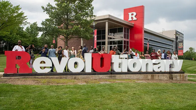 The 2023 cohort of Mandela Washington Fellows posing on the Revolutionary sculpture from the university's 250th anniversary.