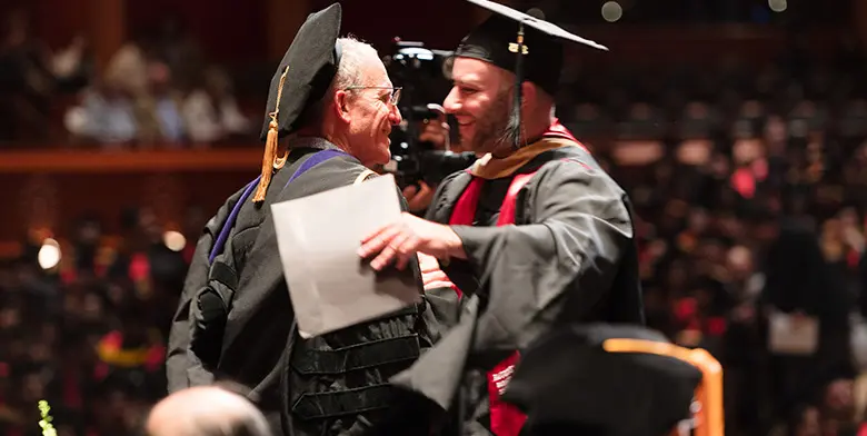 Professor Jay Soled, director of the Master of Accountancy in Taxation Program, congratulates a graduating student.