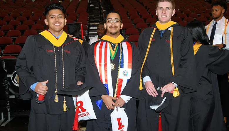 Three Rutgers Business School students pose for the camera before the start of the Rutgers University-Newark Commencement Ceremony.