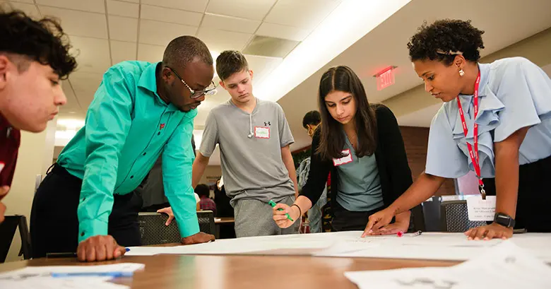 Two Mandela Washington Fellows work with high schoolers participating in Rutgers Business School's summer supply chain management program.