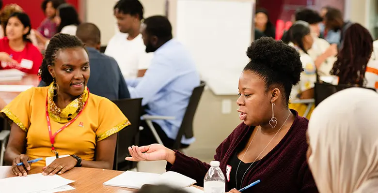A team of students in the summer supply chain program work alongside Etta Madete, one of the Mandela Washington Fellows.