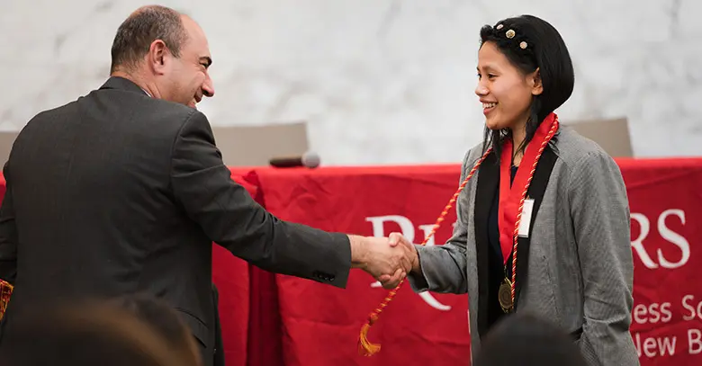 Graduating senior Sokunnanya Om is congratulated by Rob Kurland, senior associate dean of undergraduate students.