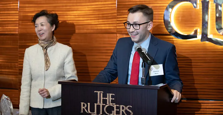 Rutgers Business School Dean Lei Lei with award recipient Christian Buren at the podium.
