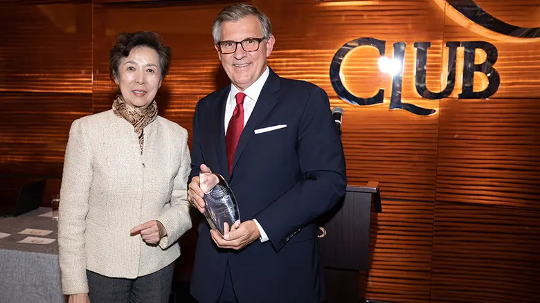 Rutgers Business School Dean Lei Lei stands with MBA alumnus Len DeCandia who is holding his award.