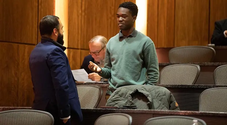 Rutgers Business School student Alex Simeon speaking with a guest at the Business and Community Engagement Symposium.