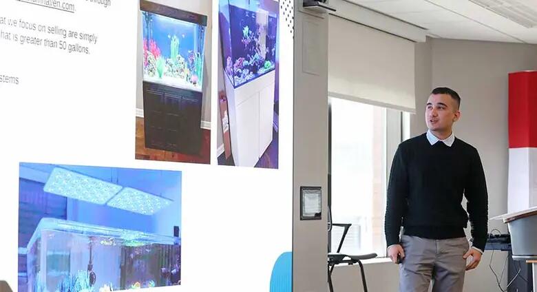 Rutgers Business School student Anis Alamov explains his start-up business at the Rutgers business plan competition.
