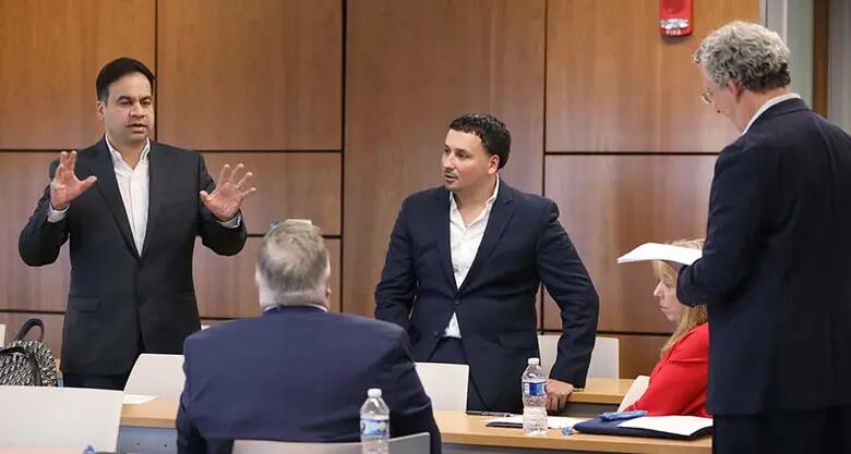 Judges at the Rutgers Business School business plan competition discuss the contestants.