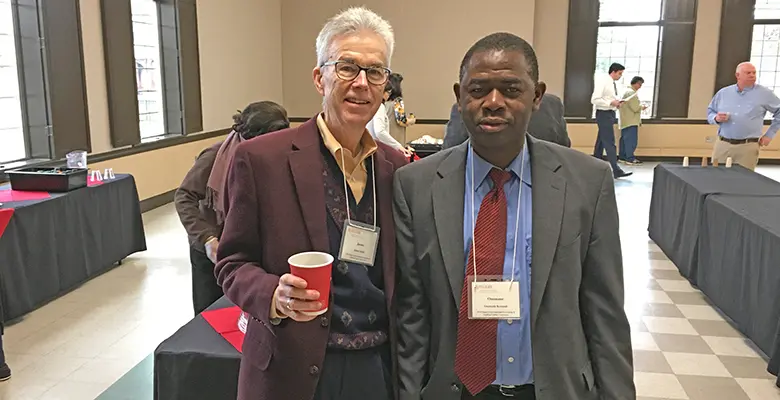 Professor Jim Smith and alumnus Ousmane Kromah catch up over coffee during a break.
