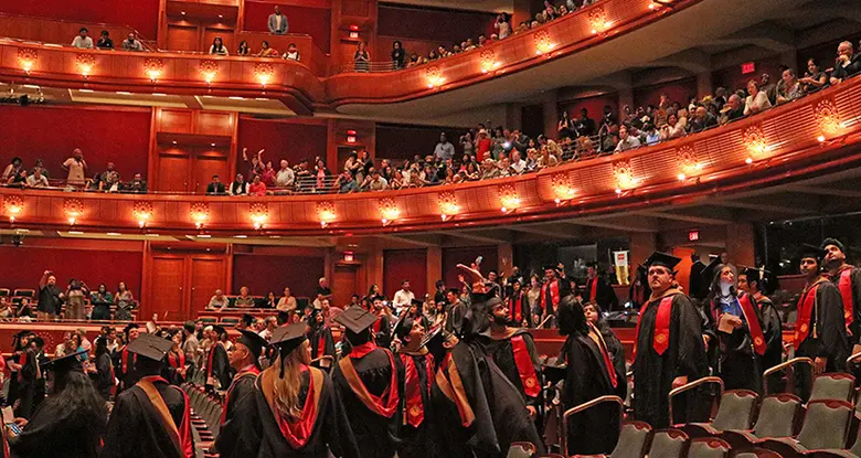 Graduating Rutgers graduate students scan the crowd for family and friends as they file into the New Jersey Performing Arts Center.