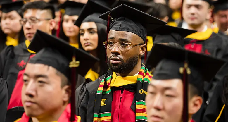 Graduating students at Rutgers Business School listen to the convocation speaker.