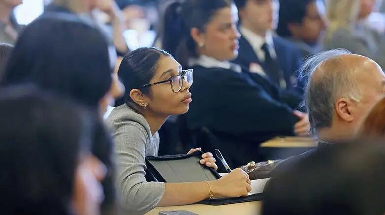 Student listens intently to a presentation during the marketing summit.