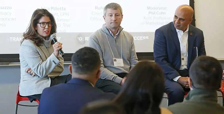 Three professionals participating on a panel discussion at Rutgers Business School's annual marketing summit.