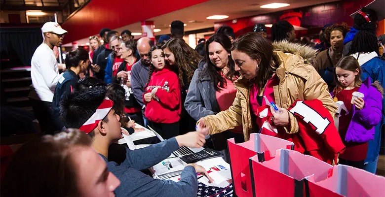 Two women interact with students at crowded tables