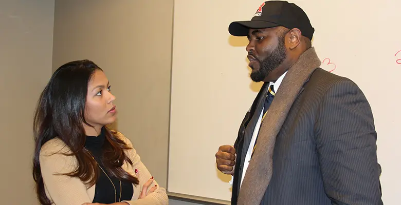 Derrick Griggs, chief operations officer at the Affordable Housinal Alliance, speaks with a student after the panel discussion.