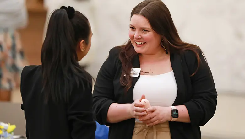 Hannah Salto, assistant dean of student support, engagement and leadership, speaks with an alumna of Women BUILD.