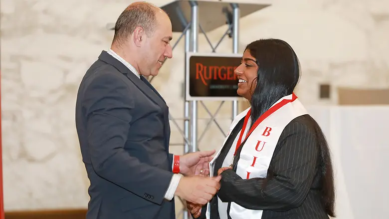 Rutgers Business School Senior Associate Dean Robert Kurland congratulates Sejal Rajagopalan, one of the senior students celebrated during the summit.