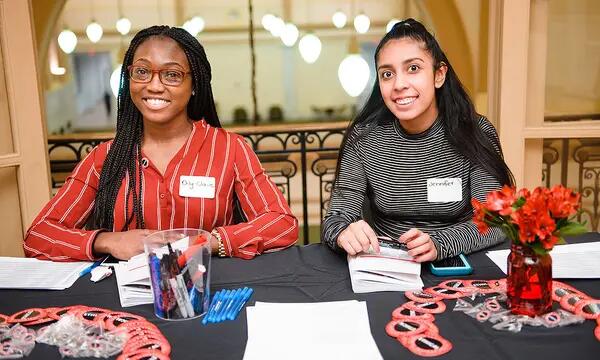 Two Interns help out at a table at an IEL event