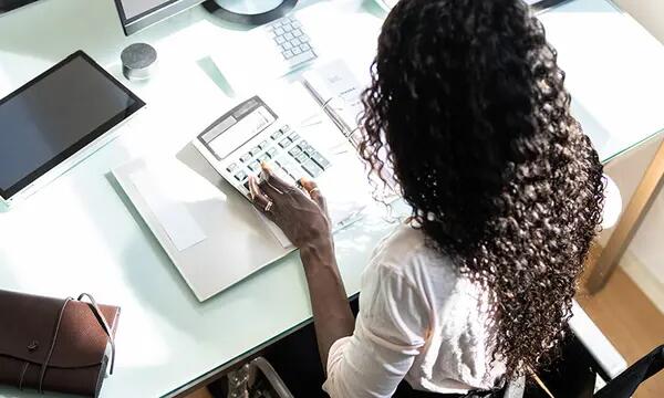 woman in a wheelchair using a calculator