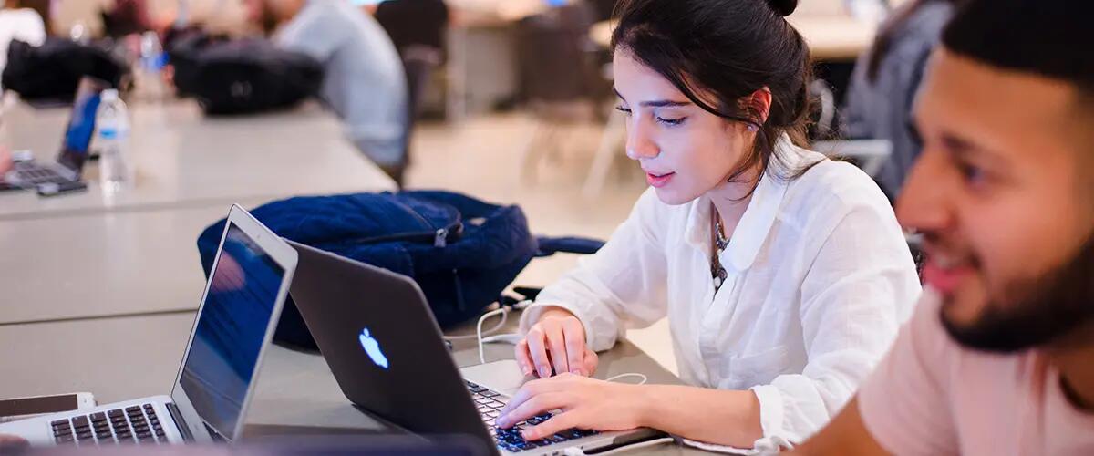 female student typing on laptop