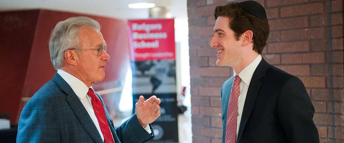 Alumni speaks with professor at RBS event.