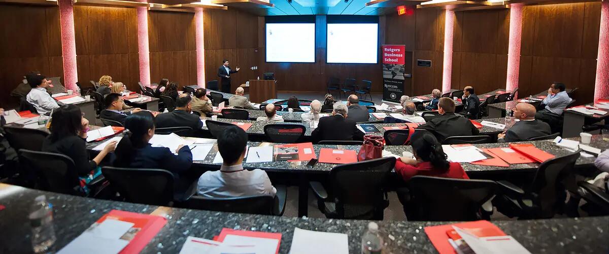 Wide angle shot of audience viewing presentation on projection screens