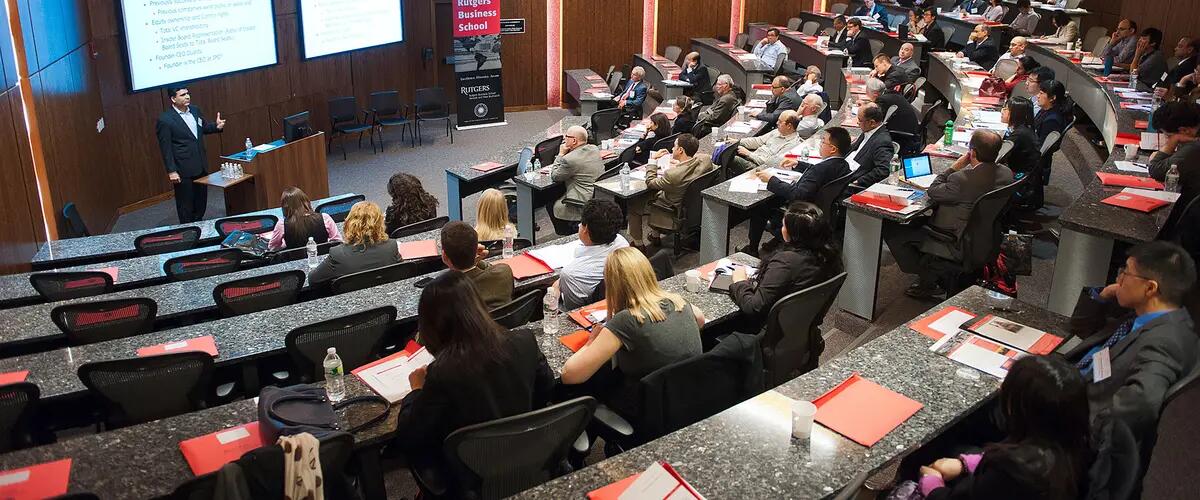 Wide angle shot of audience viewing presentation on projection screens