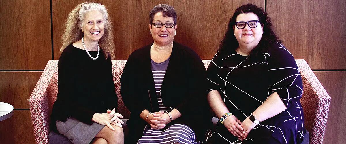 Three members of IEL sitting together on a couch
