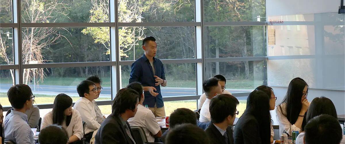 A student stands up and speaks to his fellow classmates of the Master of Financial Analysis program