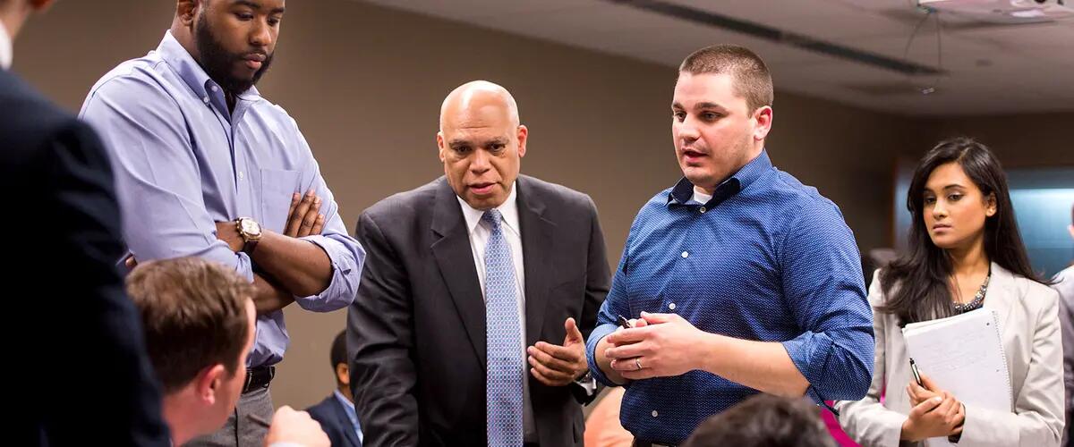 Students and faculty gathered closely in class whilst engaged in discussion