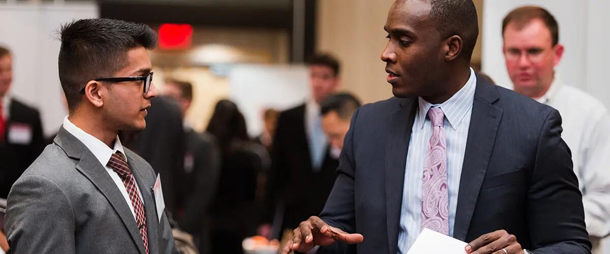 RBS student speaks with business professional at networking event. 