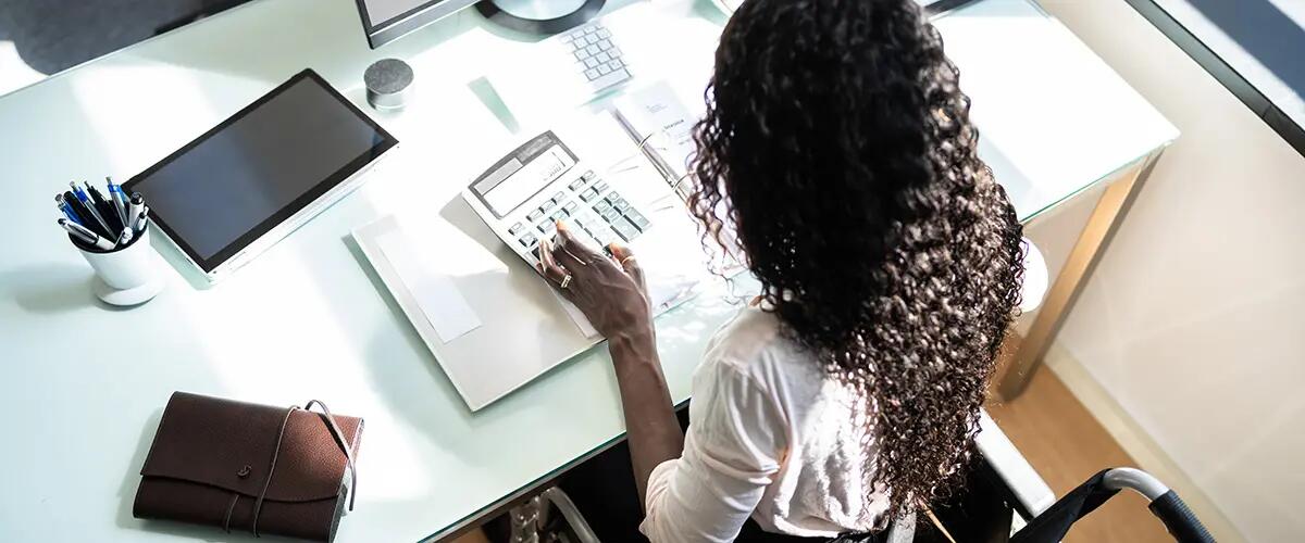 woman in wheelchair using calculator