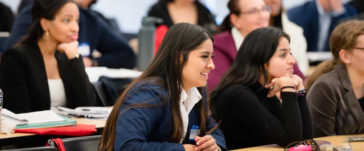 student smiling while listening to lecture