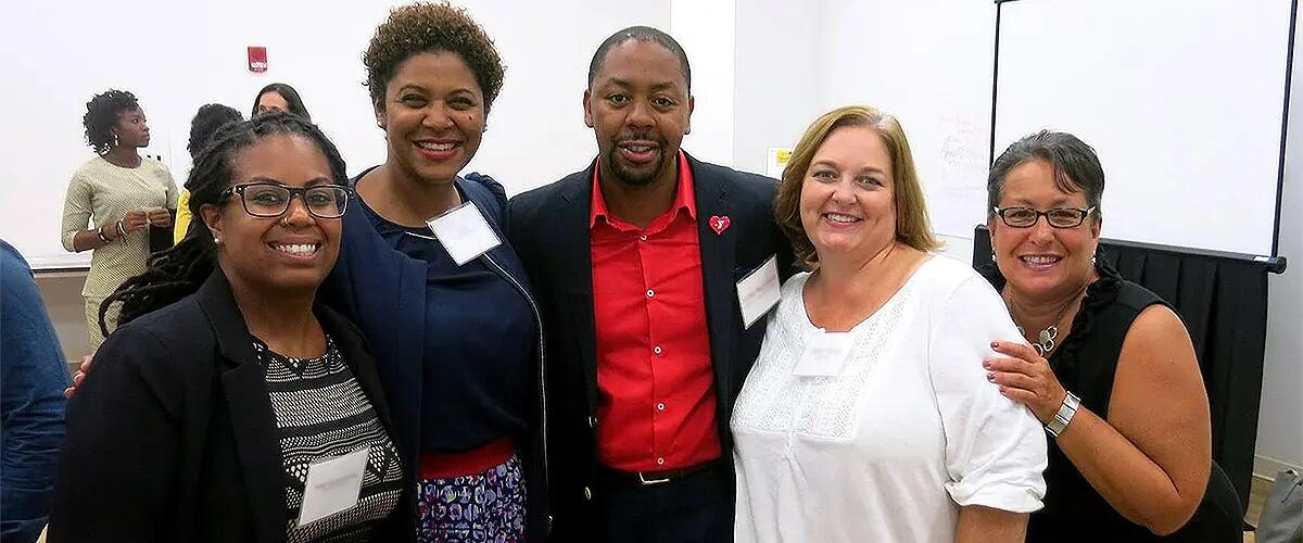5 people pose together at a mixer for the program